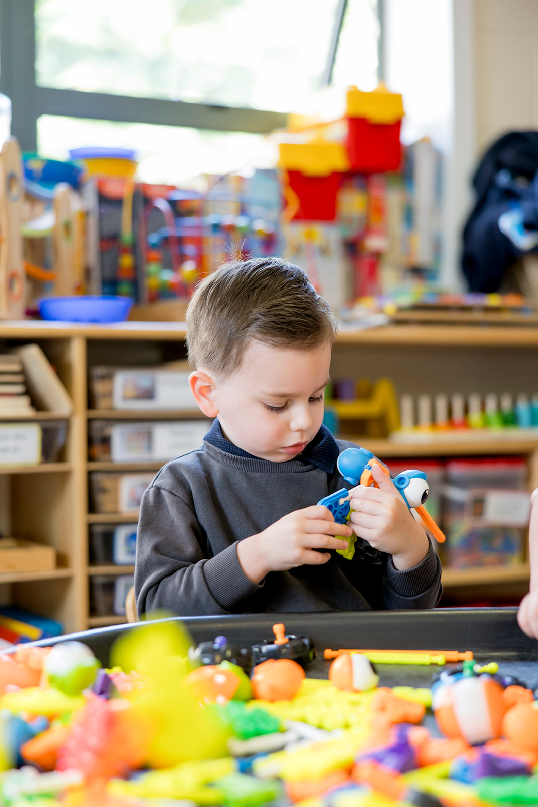 A boy concentrating on fitting construction toy pieces together